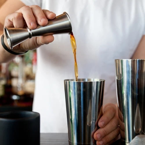 Viski Japanese jigger being used to measure cocktail ingredients in a chic home bar.