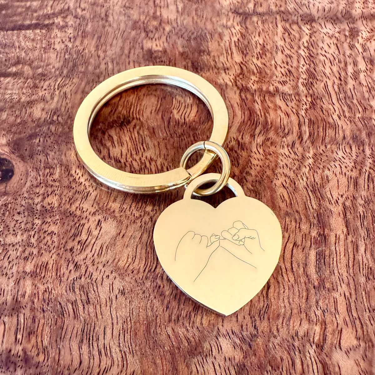 pink promise symbol engraved on gold heart keychain