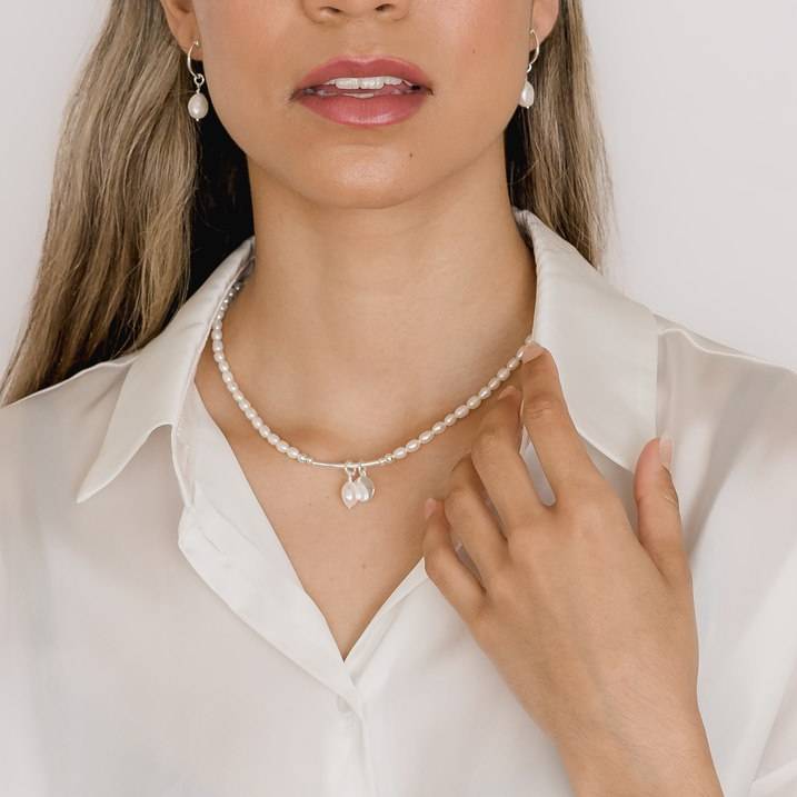 closeup photo of pearl necklace and earrings