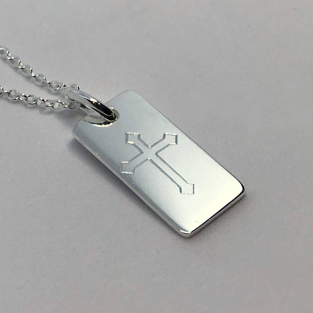 cross engraved on a silver bar pendant