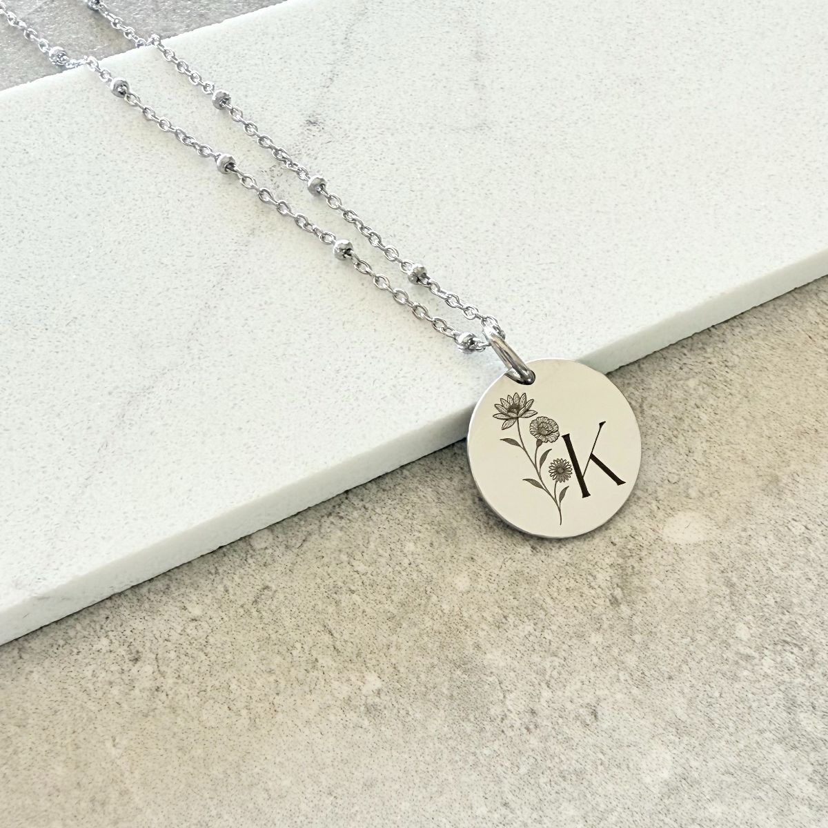 custom engraved disc necklace with initial K and flowers