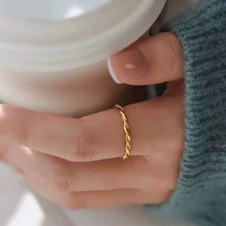 gold twisted rope ring on women's hand 
