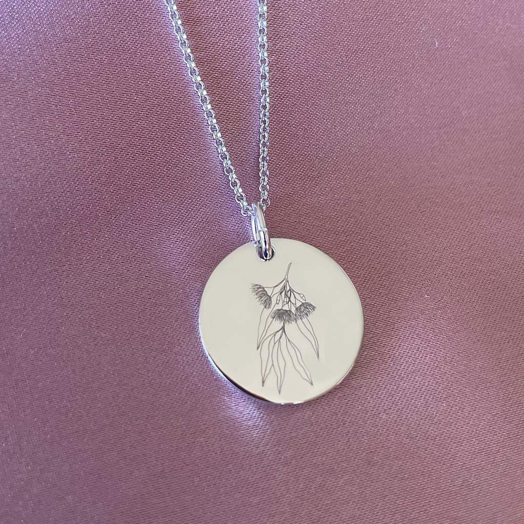large disc necklace with native flowers engraved
