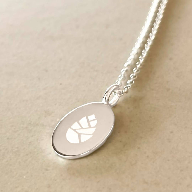 oval pendant engraved with company logo