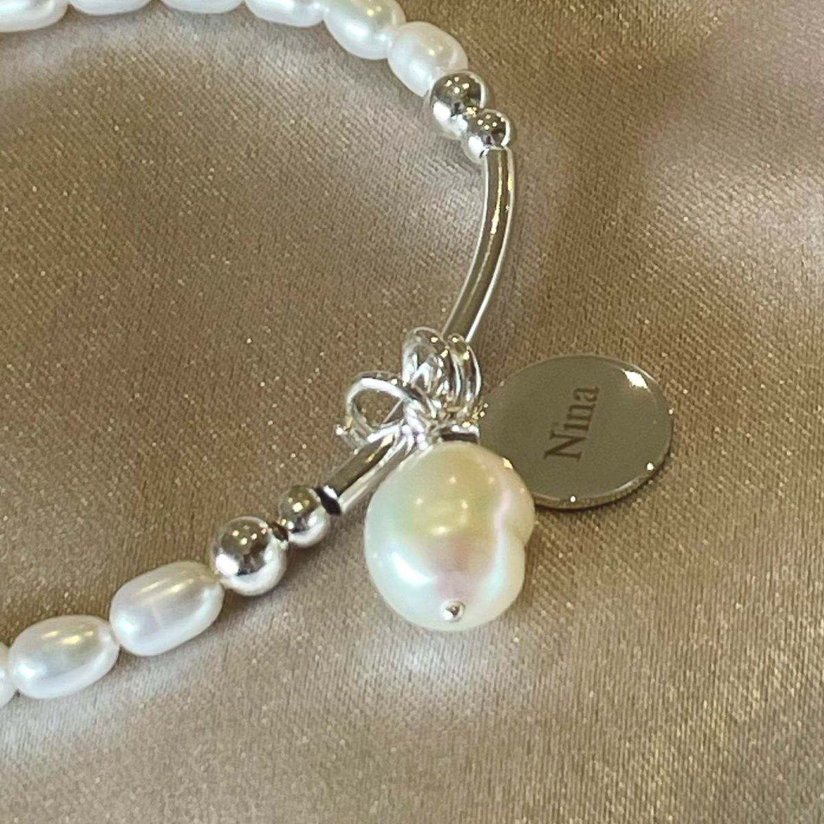 pearl bracelet with disc charm engraved with name nina