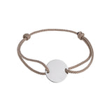 Bracelet with a round disc pendant on a beige cord against a white background