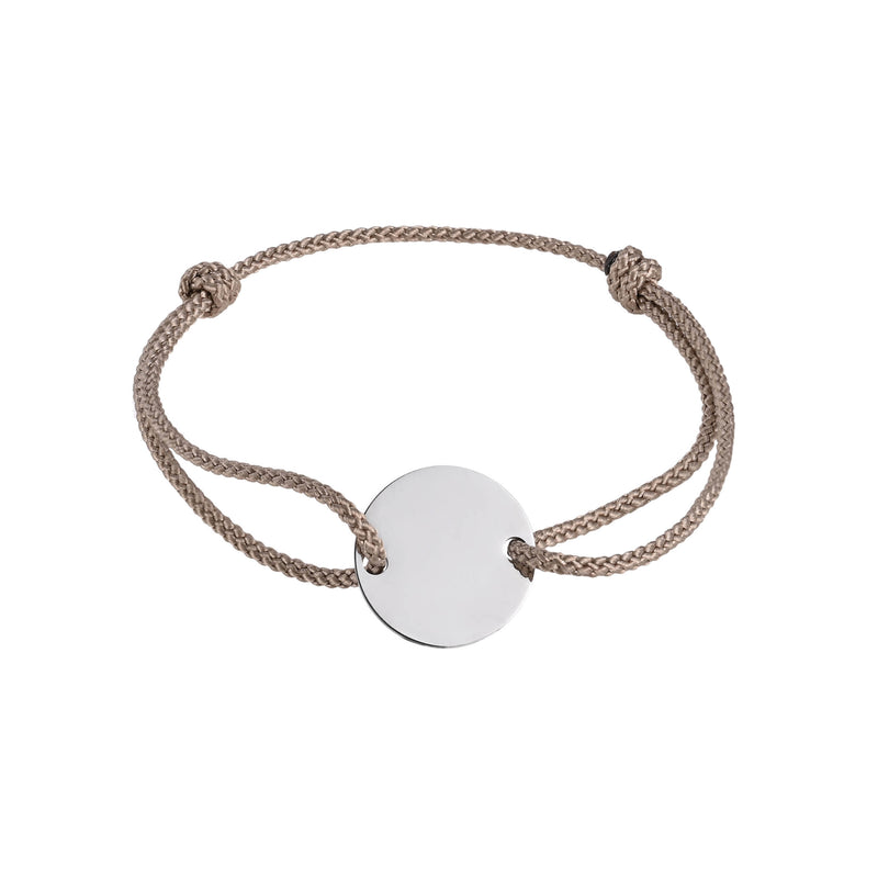 Bracelet with a round disc pendant on a beige cord against a white background