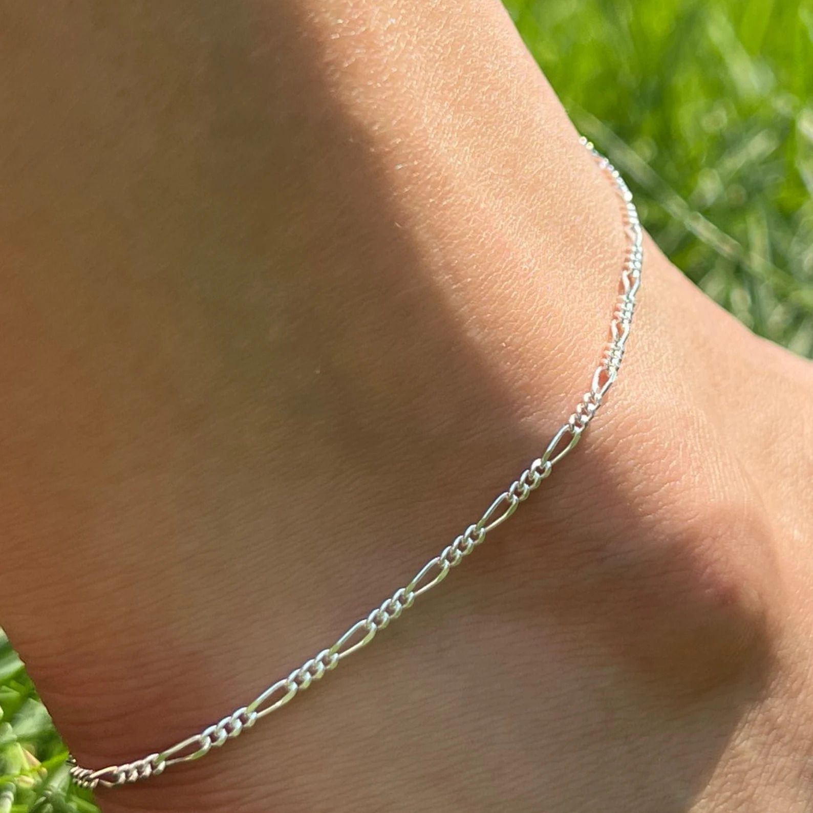 figaro Silver anklet on a person's ankle with a grassy background