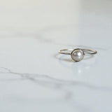 silver pearl ring on marble counter top