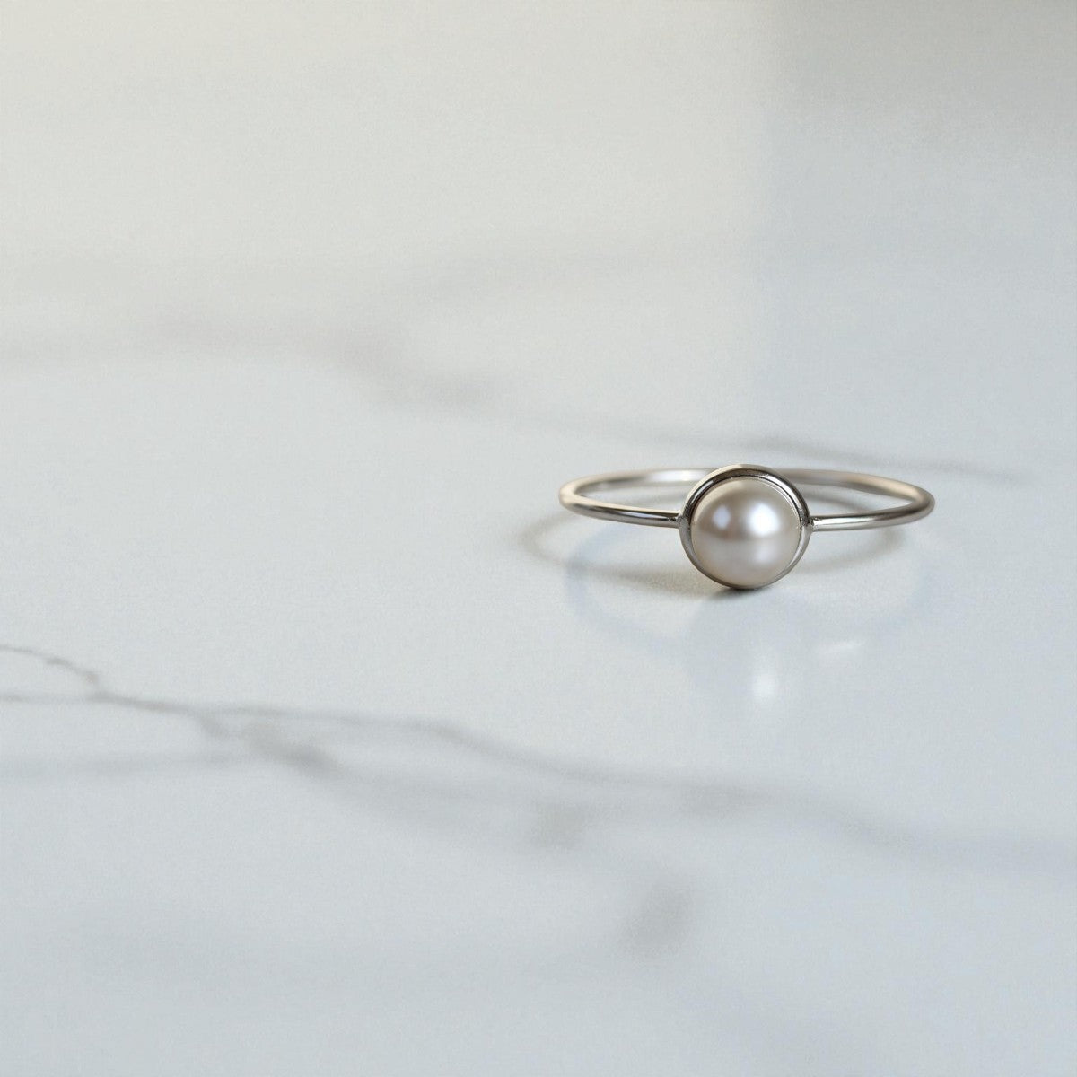 silver pearl ring on marble counter top