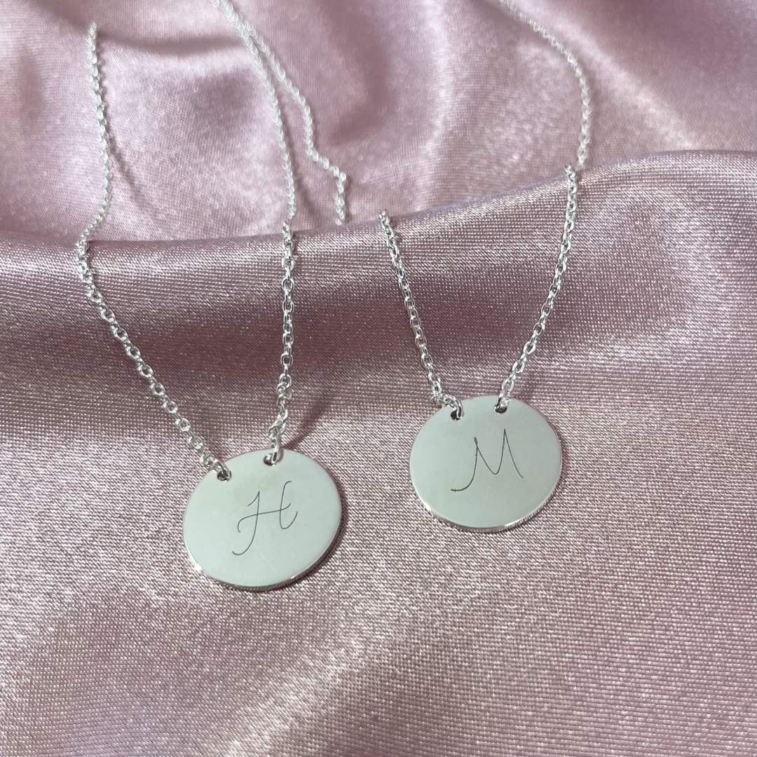 suspended disc necklace with initial H and M engraved