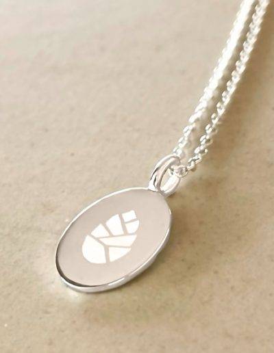 oval pendant engraved with company logo