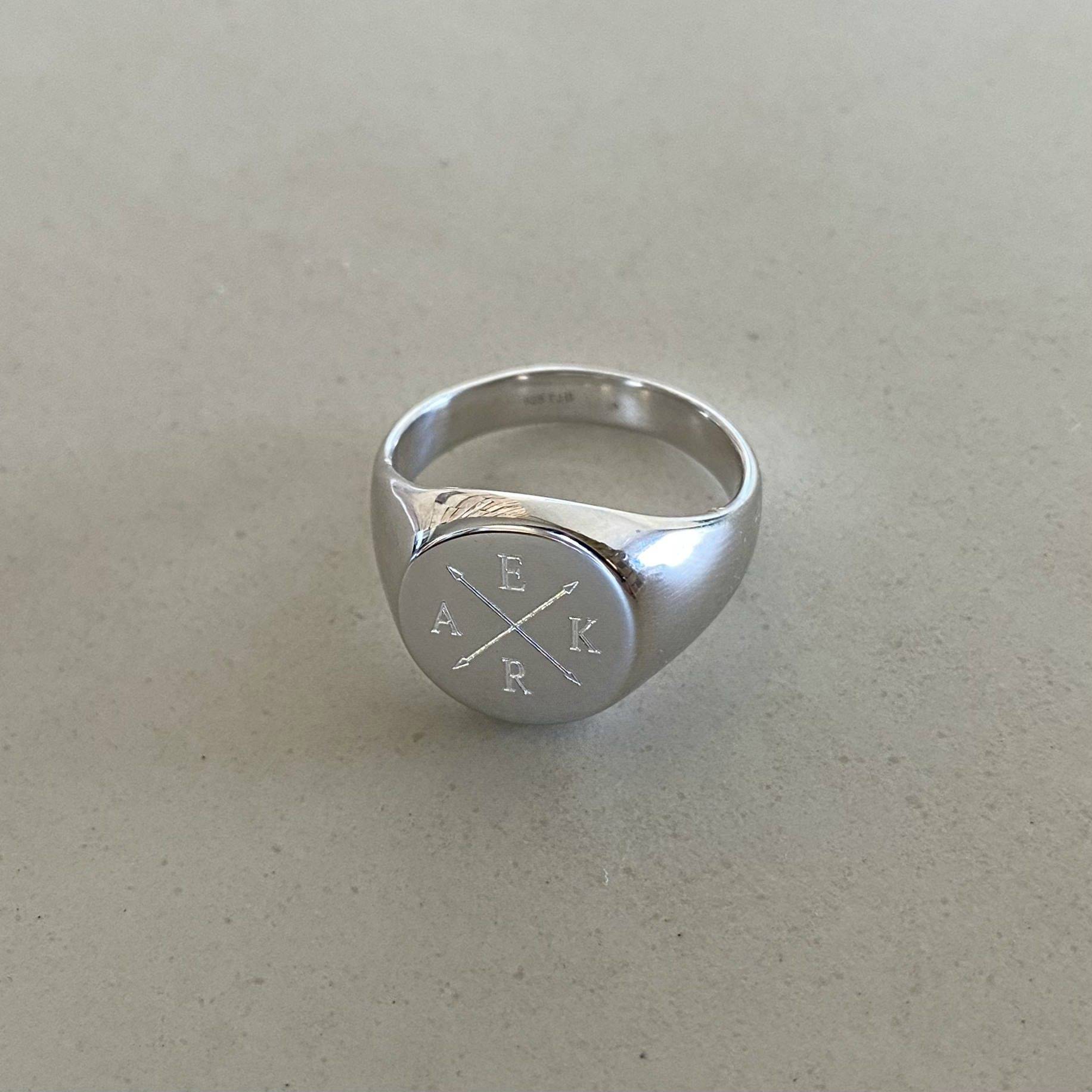 mens signet ring engraved with crossed arrows and 4 initials