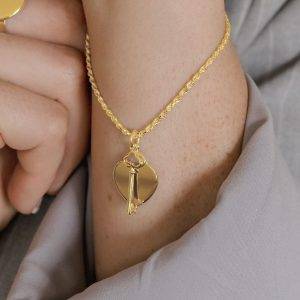 yellow gold rope bracelet and key and heart pendant